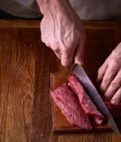 Un homme coupe un morceau de viande